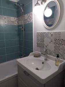 a bathroom with a sink and a mirror and a tub at Le François 1er : Au cœur de la ville, côté mer in Le Havre