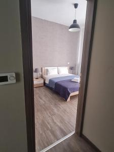- une vue sur une chambre avec un lit et un miroir dans l'établissement Trikala Easy Living B1 kai B2, à Tríkala