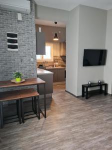 a kitchen and living room with a table and a tv at Trikala Easy Living B1 kai B2 in Tríkala