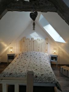 a bedroom with a large bed in a attic at Martine à la Ferme in Arrest