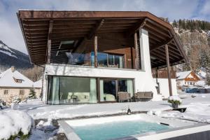 a house in the snow with a swimming pool at Chalet Villa Carolina in Selva di Val Gardena