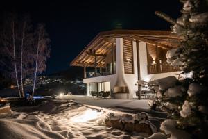 uma casa na neve à noite em Chalet Villa Carolina em Selva di Val Gardena