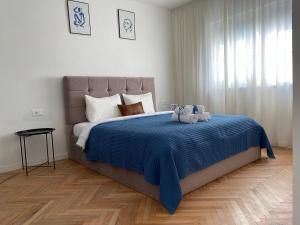 a bedroom with a large bed with a blue blanket at Myslym Shyri's Apartments in Tirana