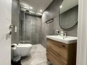 a bathroom with a toilet and a sink and a mirror at Myslym Shyri's Apartments in Tirana