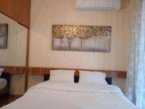 um quarto com uma cama e um quadro na parede em Central Home Kavala "private parking" em Kavala