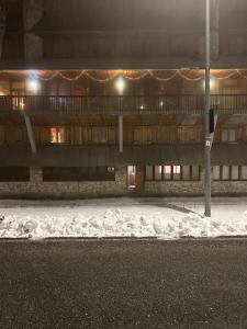 un edificio di notte con la neve davanti di Terminillo: appartamento ristrutturato a Terminillo