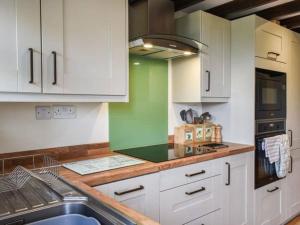 a kitchen with white cabinets and a sink at The Smithy in Richmond