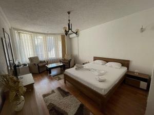 a bedroom with a bed and a living room at Deni house in Prizren