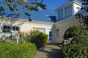 uma casa branca com um telhado azul em Haus Weisse Möwe Weisse Möwe 3 em Cuxhaven