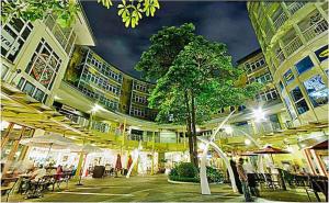 ein Gebäude mit einem Baum mitten im Innenhof in der Unterkunft BGC Private Apartments in Manila