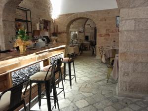a restaurant with a bar with chairs and tables at Palazzo Francesco Grassi in Aradeo
