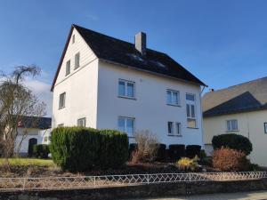 una casa blanca con techo negro en Ferienwohnung Sonne en Beltheim