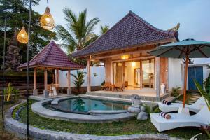 a villa with a swimming pool and a house at Amaya Sebatu Villa in Ubud