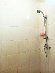 a shower with a shower head in a bathroom at Loka Anyar Guest House in Kerobokan