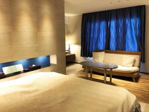 a bedroom with a bed and a blue curtain at Hotel Ange in Fukuyama