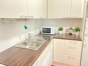 a kitchen with a sink and a microwave at Itäkadun Studio Apartment in Lahti