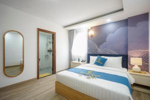 ニャチャンにあるMoonlight Nha Trang Hotelの大きなベッドと鏡のある寝室