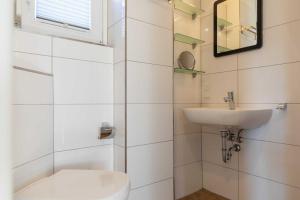uma casa de banho branca com um lavatório e um WC em Haus im Kreuzweg CASA Blanca 2 em Cuxhaven