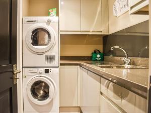 a kitchen with a washing machine and a sink at Stags Cottage in Babcary