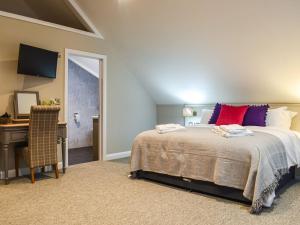 a bedroom with a bed and a desk with a computer at Stags Cottage in Babcary