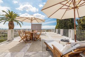 a patio with a table and chairs and umbrellas at Relais Montepepe Winery & Spa in Montignoso