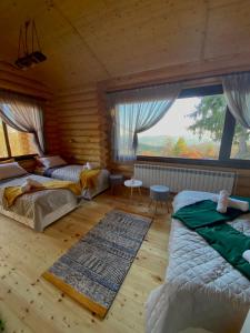 a bedroom with two beds and a large window at Вила Брезите in Pamporovo