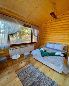 sypialnia z łóżkiem i dużym oknem w obiekcie Вила Брезите w mieście Pamporowo