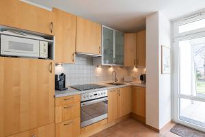 una pequeña cocina con armarios de madera y una ventana en Haus Essen Essen 5 en Cuxhaven