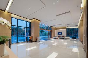een kantoorlobby met witte vloeren en grote ramen bij Holiday Inn Express Shunde Daliang, an IHG Hotel in Shunde