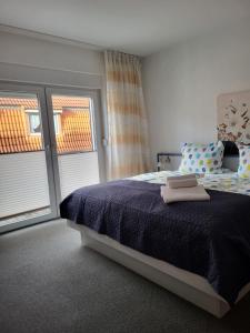 a bedroom with a bed with two towels on it at Hotel Am Deich in Norddeich