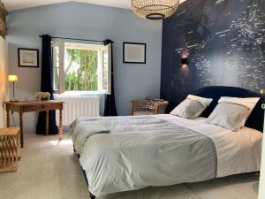 a bedroom with a large bed with a blue wall at La Chaise Haute in Hagetmau