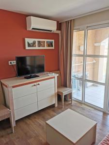 una sala de estar con TV de pantalla plana en una cómoda en APPARTEMENT CAP ESTEREL CLIMATISE VUE MER, en Agay - Saint Raphael