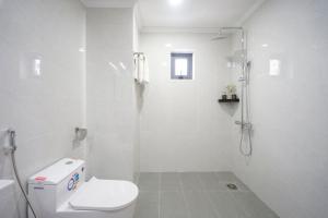 uma casa de banho branca com um chuveiro e um WC. em Moonlight Nha Trang Hotel em Nha Trang