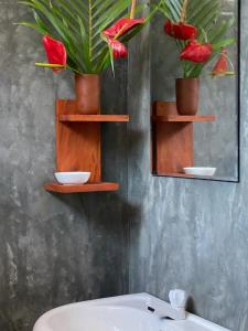 a bathroom with two shelves with flowers and a sink at Light house beach home in Matara