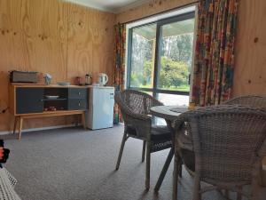a kitchen with a table and chairs and a refrigerator at Pin Oaks in Whanganui