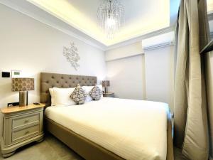 a bedroom with a white bed with a lamp and a window at Beautiful 4-Bedroom Townhouse in Sliema in Sliema