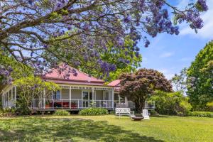 una casa con techo rosa y patio en 4 Bedroom Farm Cottage on the Bellinger River, en Bellingen