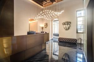 a lobby with a reception desk and chandelier at Martius Private Suites Hotel in Rome