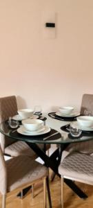 una mesa de comedor negra con platos y sillas en Lovely 2 bedroom Flat with Free Parking, en New Southgate