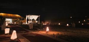 un grupo de luces en una playa por la noche en Bohemian Camp, en Merzouga