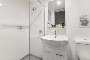 Un baño blanco con lavabo y ducha. en 4 Bedroom Farm Cottage on the Bellinger River, en Bellingen