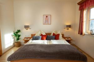 ミュールバッハ・アム・ホーホケーニッヒにあるMolteraugutのベッドルーム1室(大型ベッド1台、赤と青の枕付)