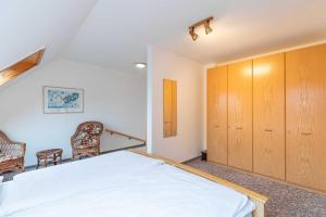 a bedroom with a bed and two chairs at Haus Relax Appartements Duhnen Haus Relax Appartements Duhnen - Wohnung 2 in Cuxhaven