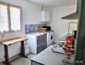a kitchen with a stove and a sink and a microwave at Cap Corse une villa dans un nid de verdure in San-Martino-di-Lota