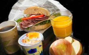 a tray with a sandwich and a glass of orange juice at Lana House in Pärnu