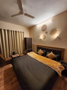 a bedroom with a large bed and a ceiling fan at Woodzo Kasol in Jari