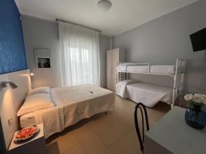 una camera con un letto e un letto a castello di Hotel Le Ali a Rimini