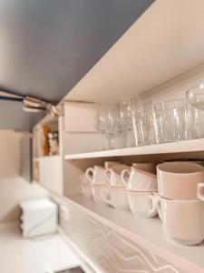 a row of cups and dishes on a shelf in a kitchen at Villa Julia in Callao Salvaje in Callao Salvaje