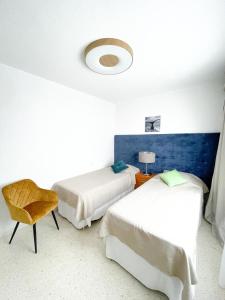 a hotel room with two beds and a chair at Villa Julia in Callao Salvaje in Callao Salvaje