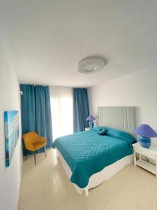 a bedroom with a blue bed and a window at Villa Julia in Callao Salvaje in Callao Salvaje